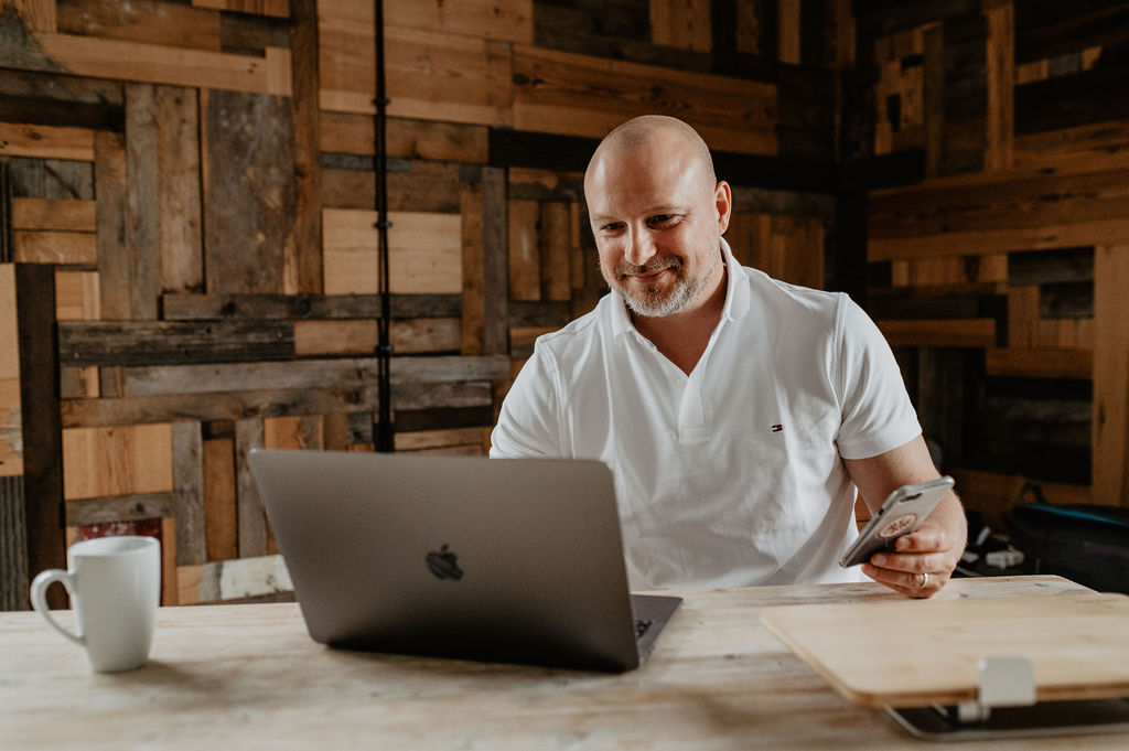 René Schwengler, Salesforce-Experte bei Digital2gether, arbeitet konzentriert an Laptop und Smartphone